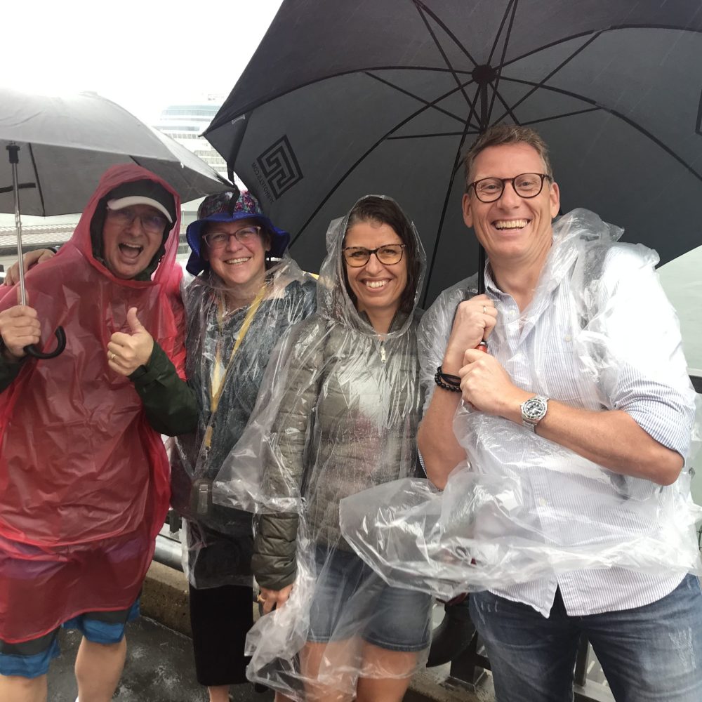 a group of people posing for a picture while holding an umbrella