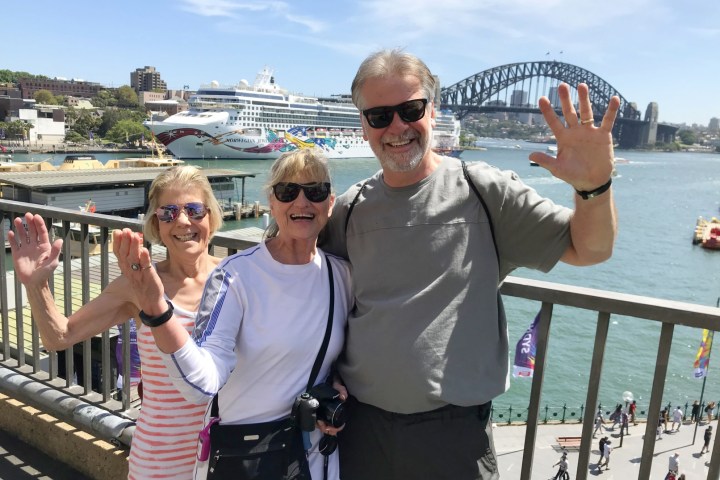 a group of people standing on a dock near the water