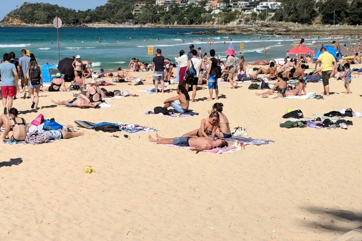 a group of people sitting at a crowded beach on a sunny day