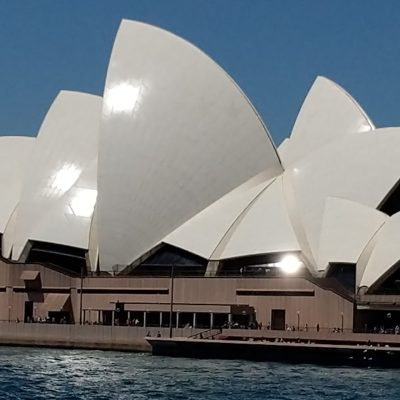 a large ship in the water with Sydney Opera House in the background