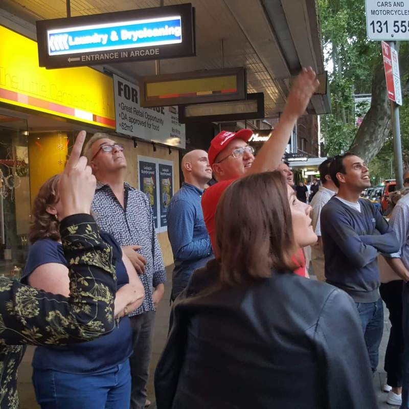 team building a group of people walking down the street talking on a cell phone