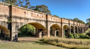 a large stone building with grass in front of a brick wall