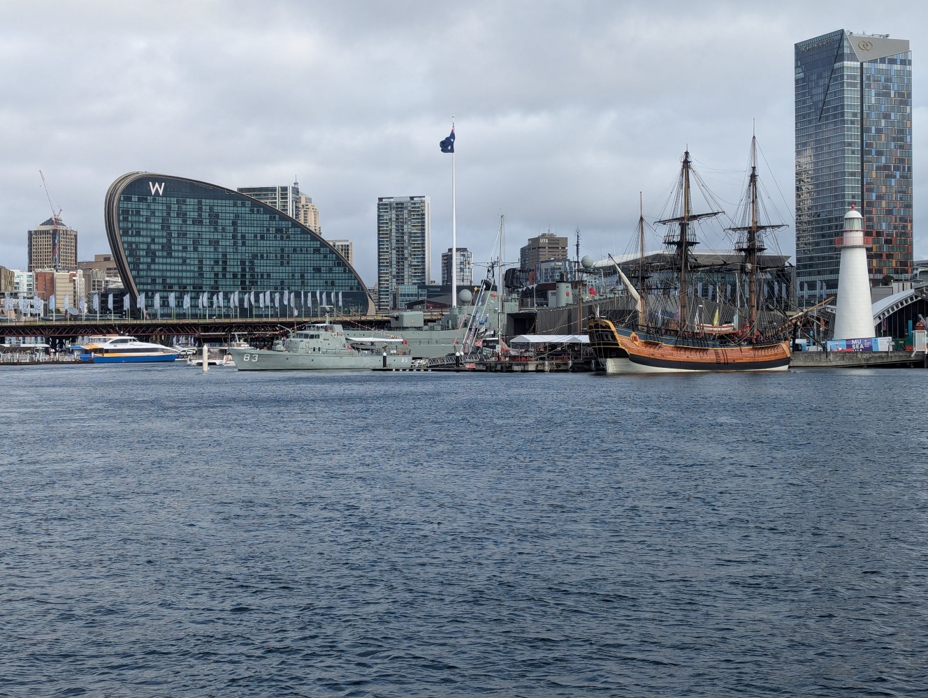 a large ship in a body of water with a city in the background