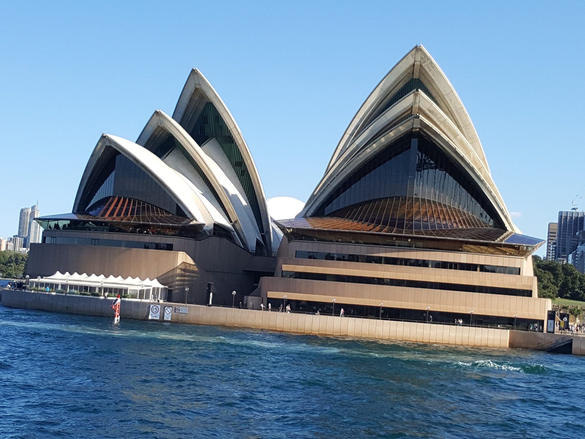 Sydney Opera House a large ship in a body of water with Sydney Opera House in the background